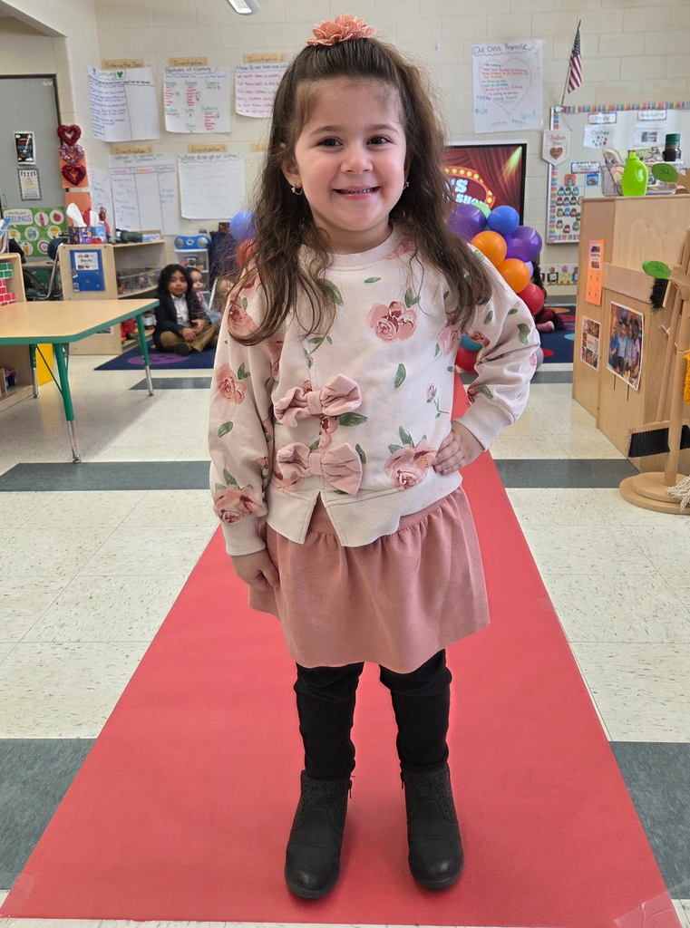 Student walking down a pretend red carpet runway