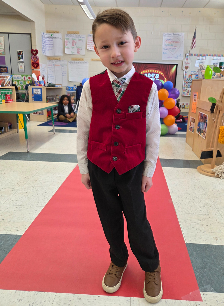 Student walking down a pretend red carpet runway