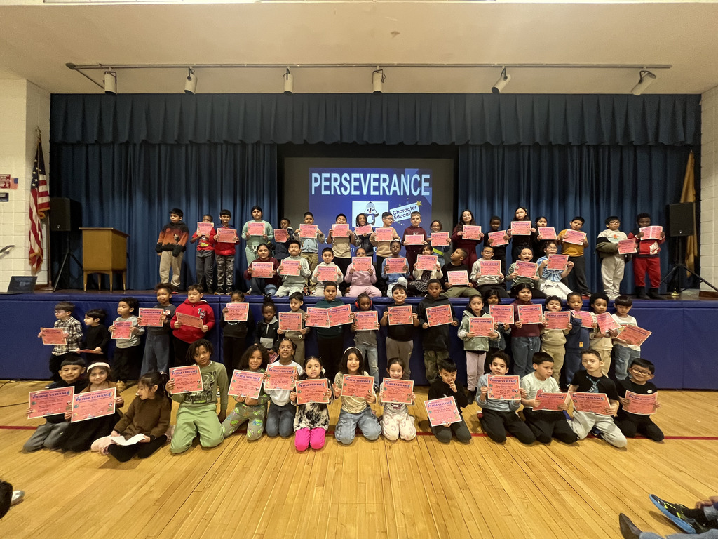 Large group of students holding certificates in front of the word perserverence