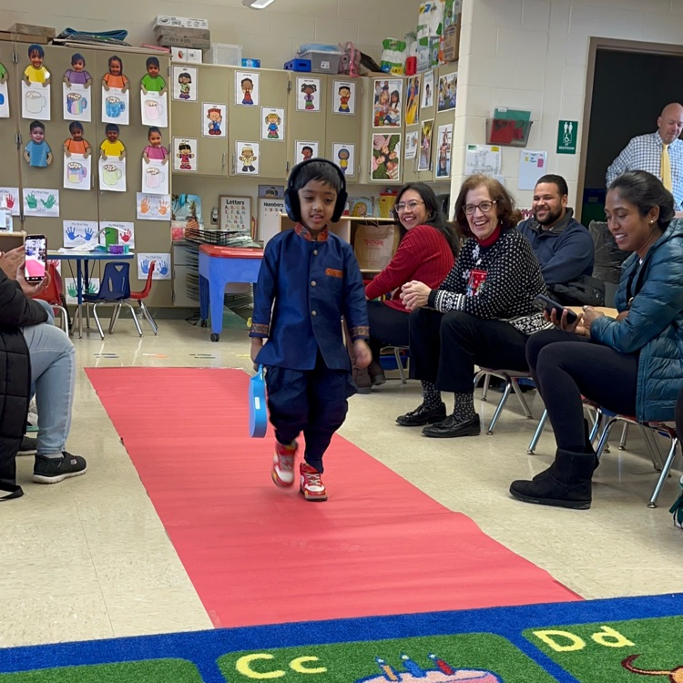Student walking down a pretend red carpet runway