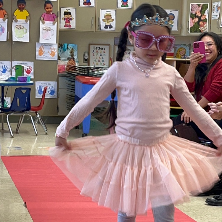 Student walking down a pretend red carpet runway