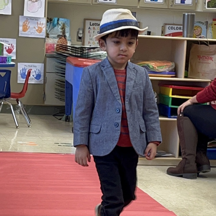 Student walking down a pretend red carpet runway