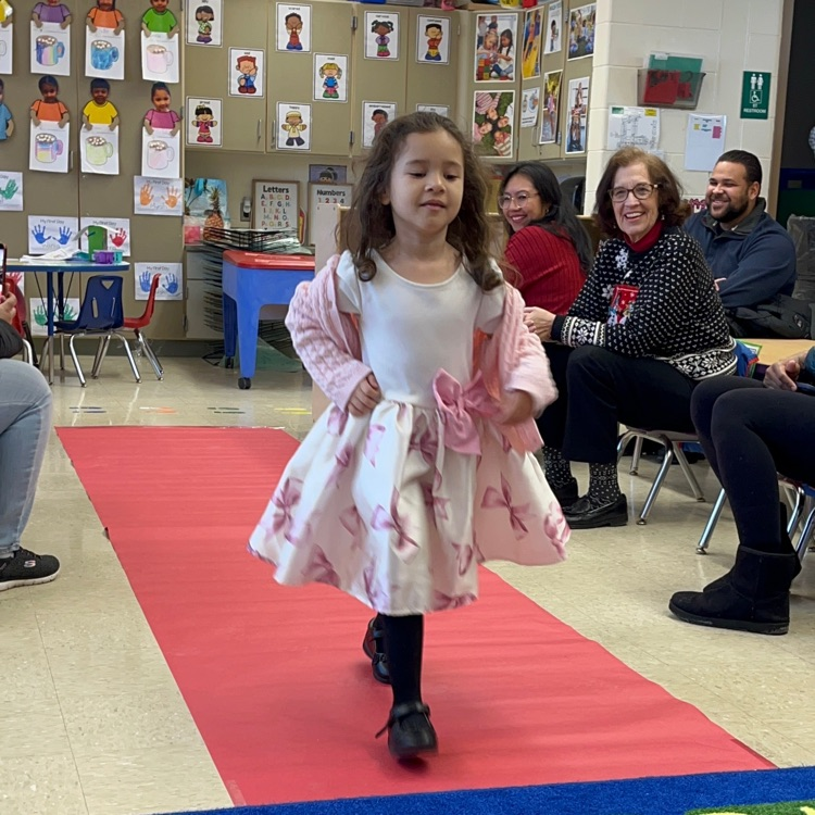 Student walking down a pretend red carpet runway