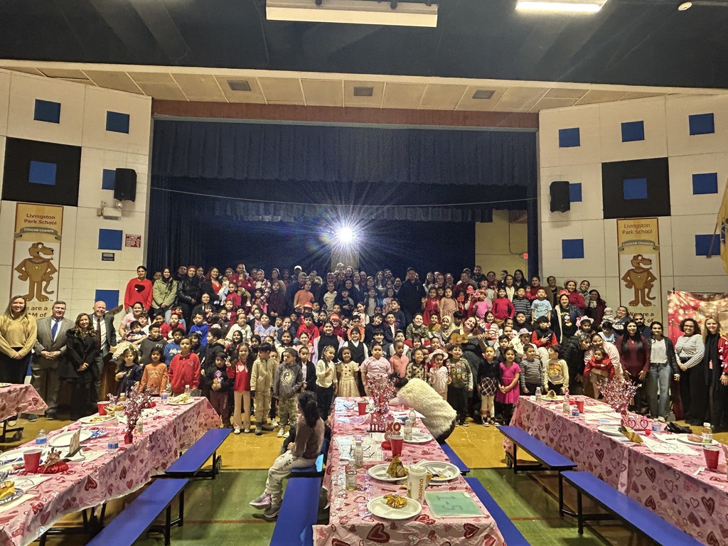 Large group of students and parents posed in a cafeteria