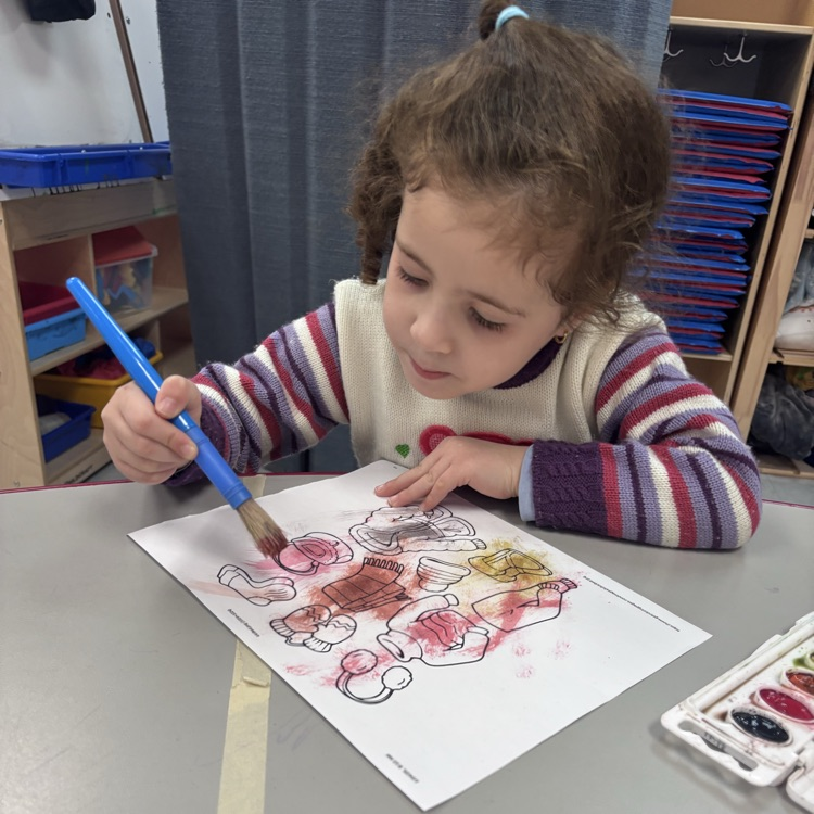 Preschool student painting at a table