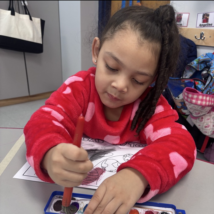 Preschool student painting at a table