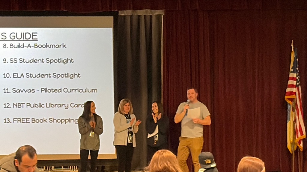 4 teachers presenting in front of a screen on stage