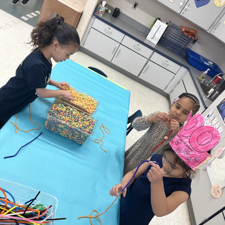 Students using cereal to make necklaces