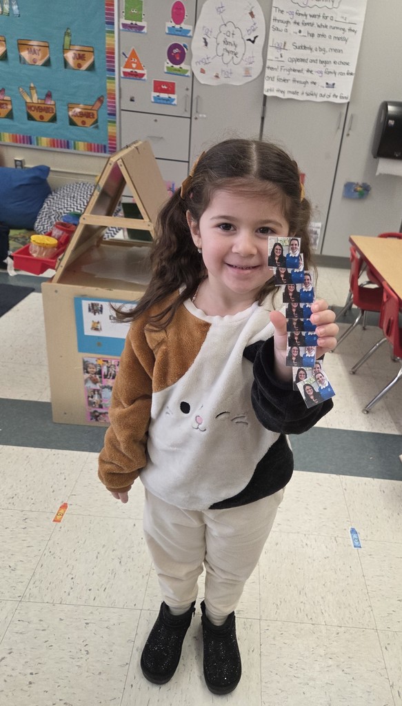 student holding small photos