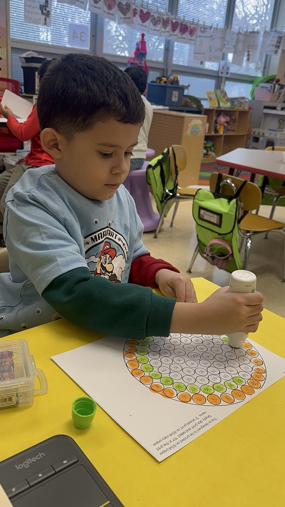Student is using dot markers to count to 100 and create a gum ball machine. 