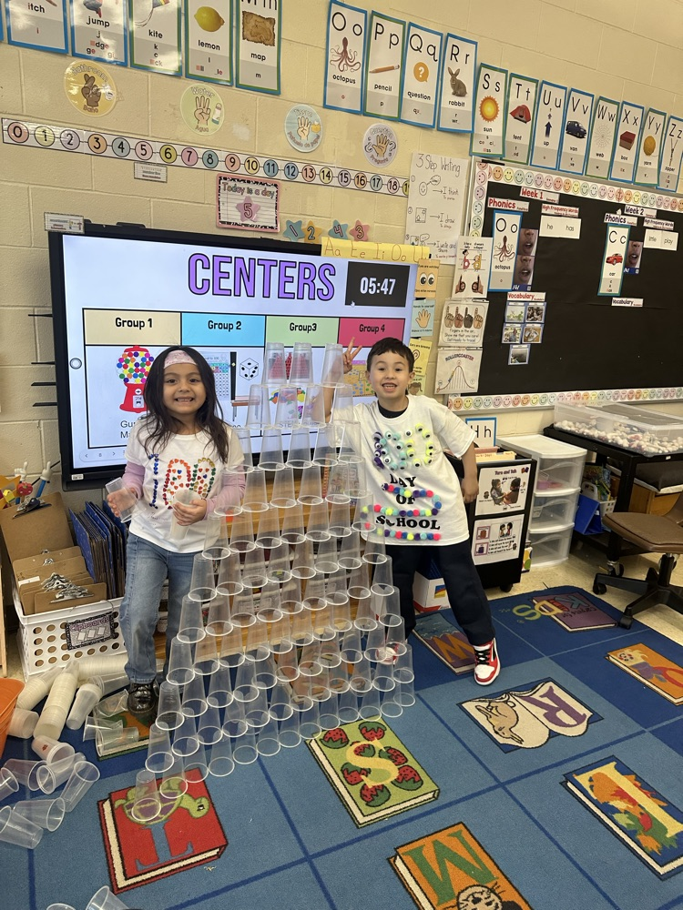 Students are working in their 100th day stations by building something with 100 cups.