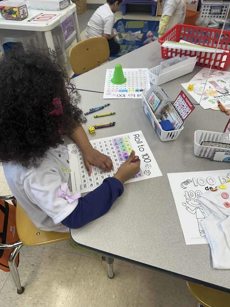 Student is rolling a die to 100 while practicing her math counting skills.