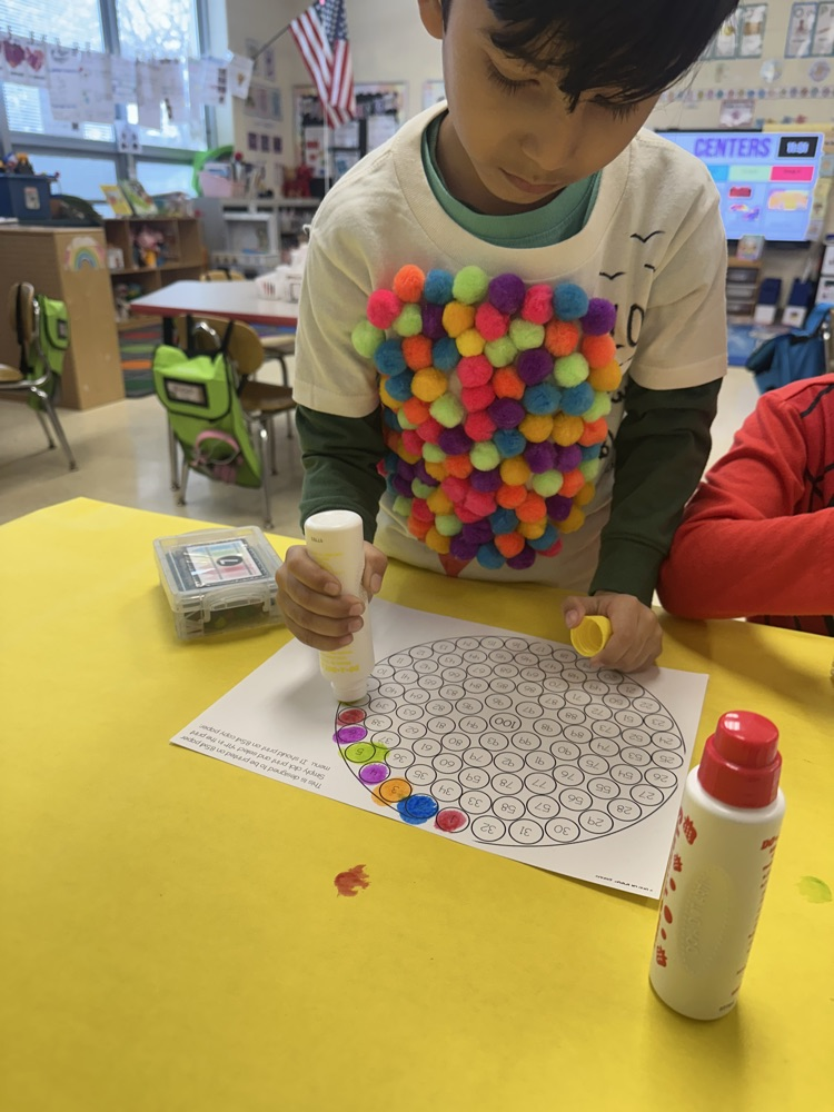 Student is using dot markers to count to 100 and create a gum ball machine. 