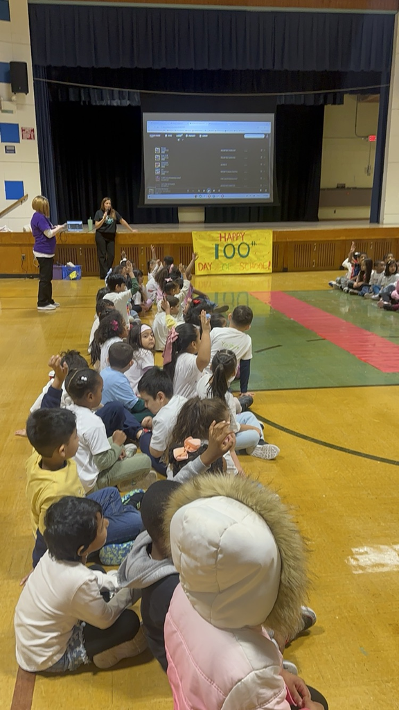 Students are posing at their kindergarten fashion show for the 100th day of school. 