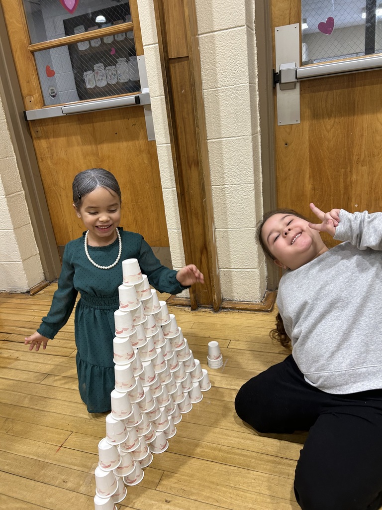 students stacking 100 cups into a pyramid