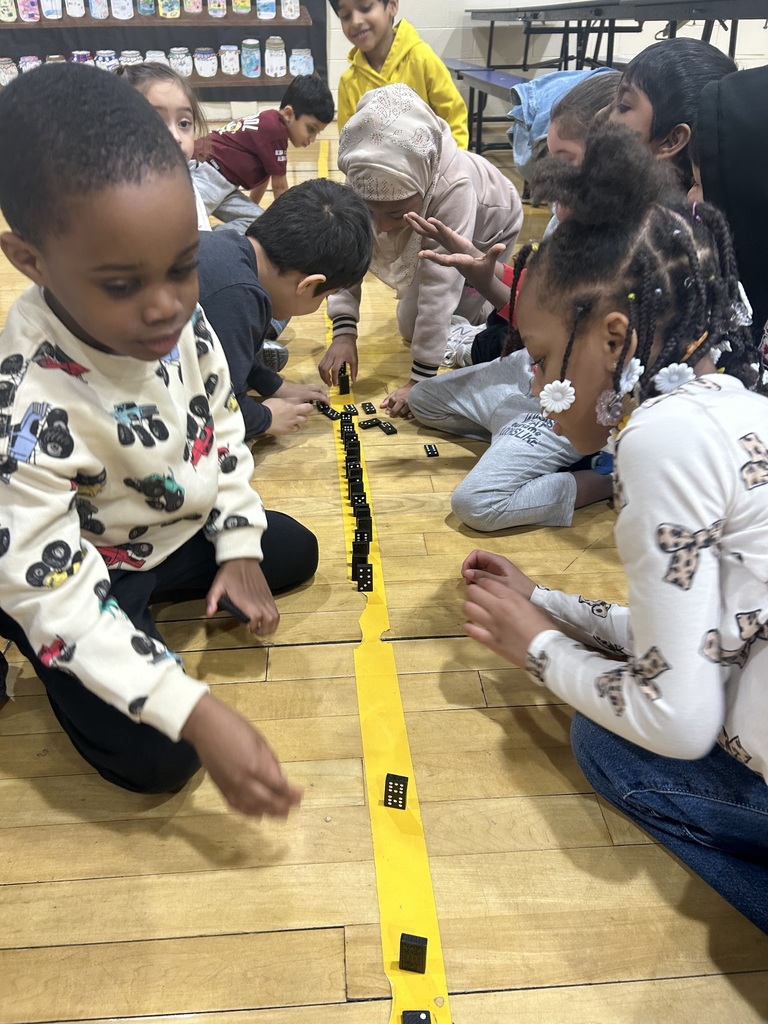 students using 100 dominoes to make a train