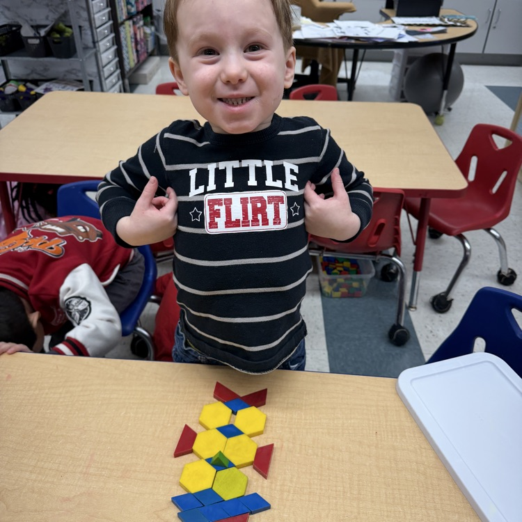 Student building with shapes at a table
