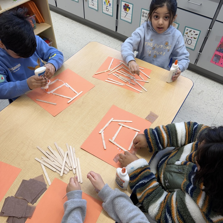 Students building with shapes at a table