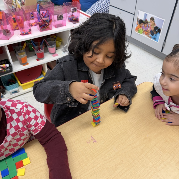 Student building with shapes at a table