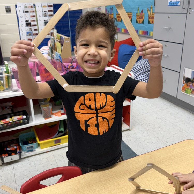 Student building with shapes at a table