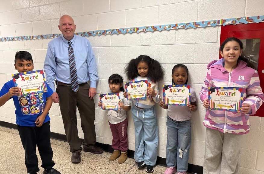 Group of students standing with certificates with their principal Friday Five 2/20/26