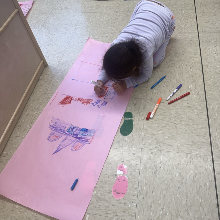Student working on the floor on colored paper