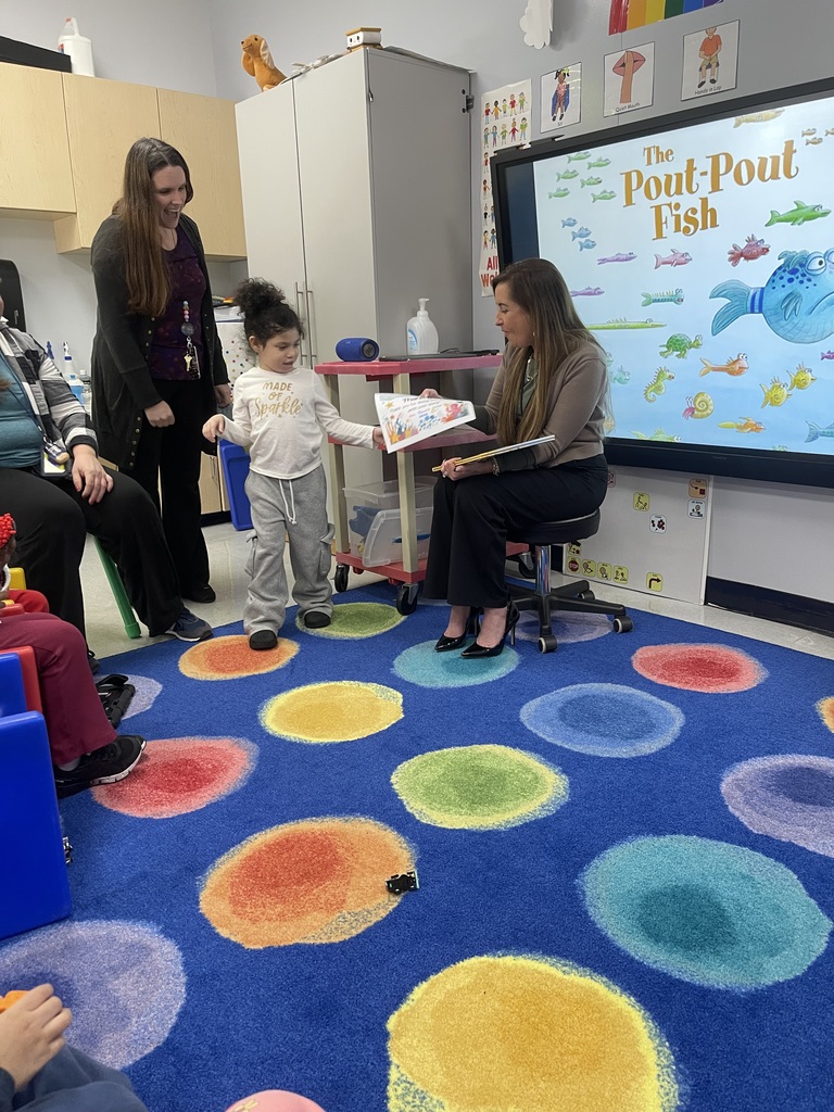 Student giving an adult a certificate of appreciation