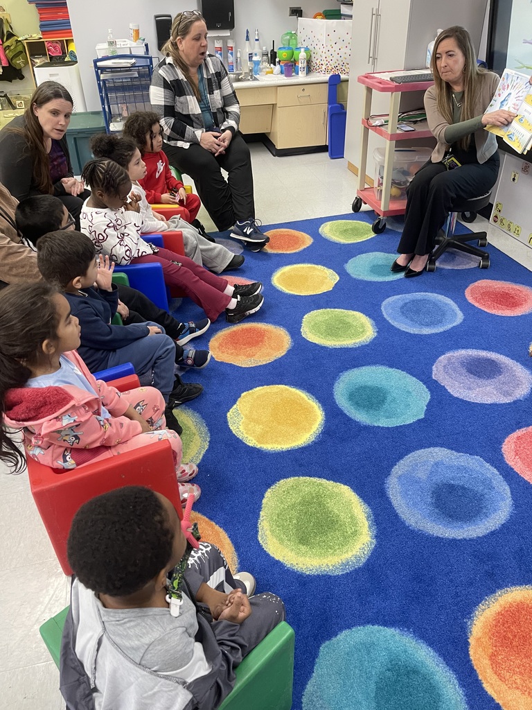 Group of students listening to a book reading by an adult