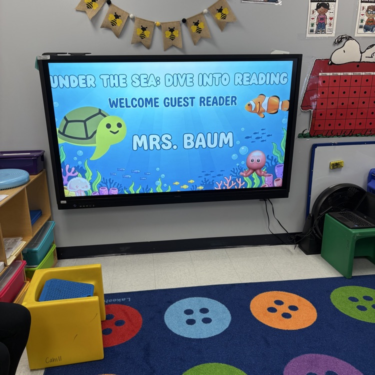 Projector screen that says welcome guest reader Mrs. Baum