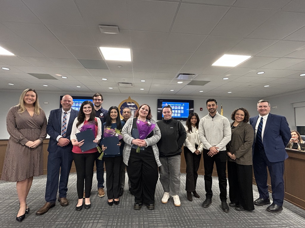 Group of adults posing at a board meeting