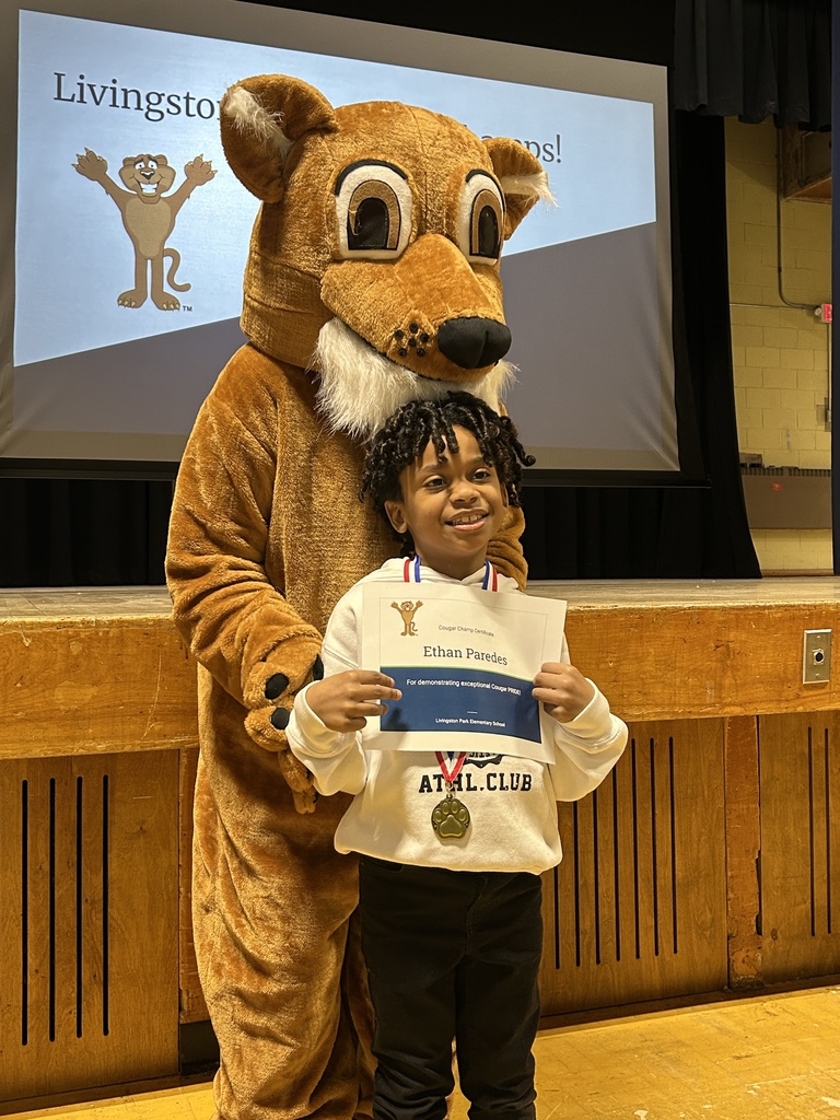 students posing with a school mascot