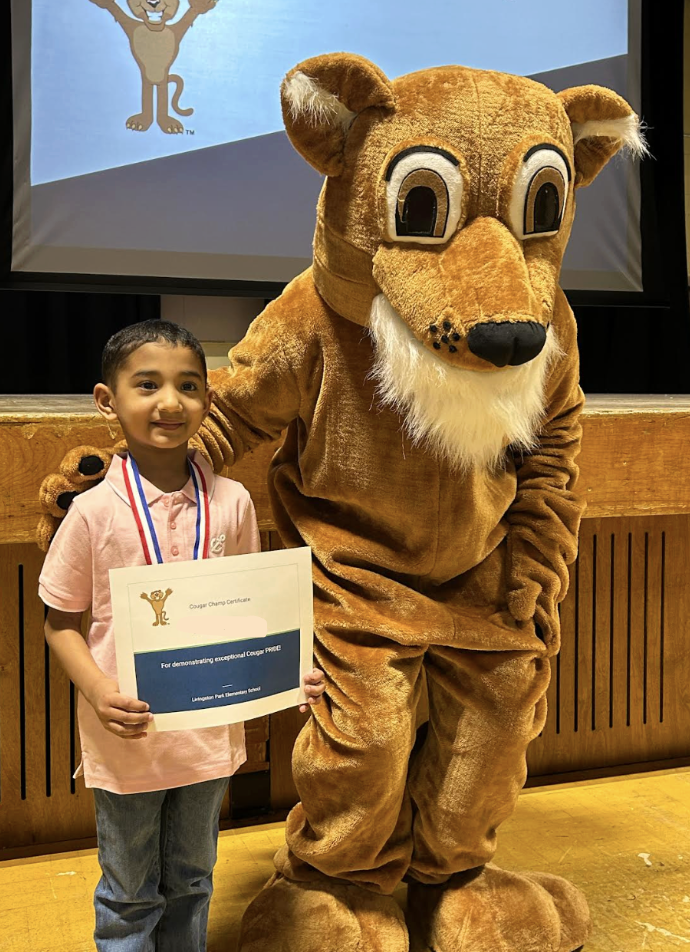 students posing with a school mascot