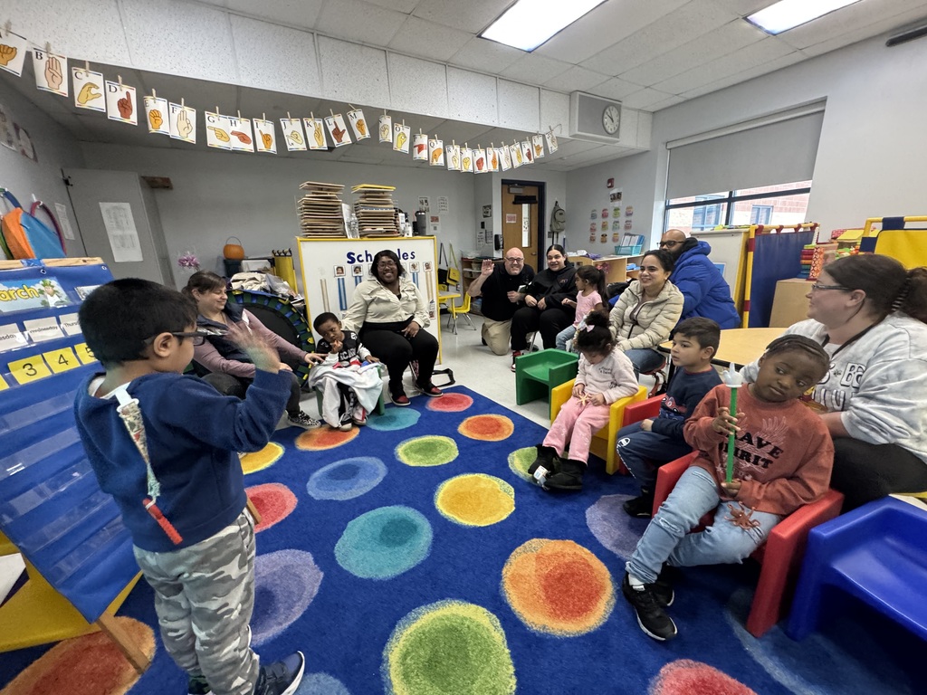 Students sitting with adults in a classroom