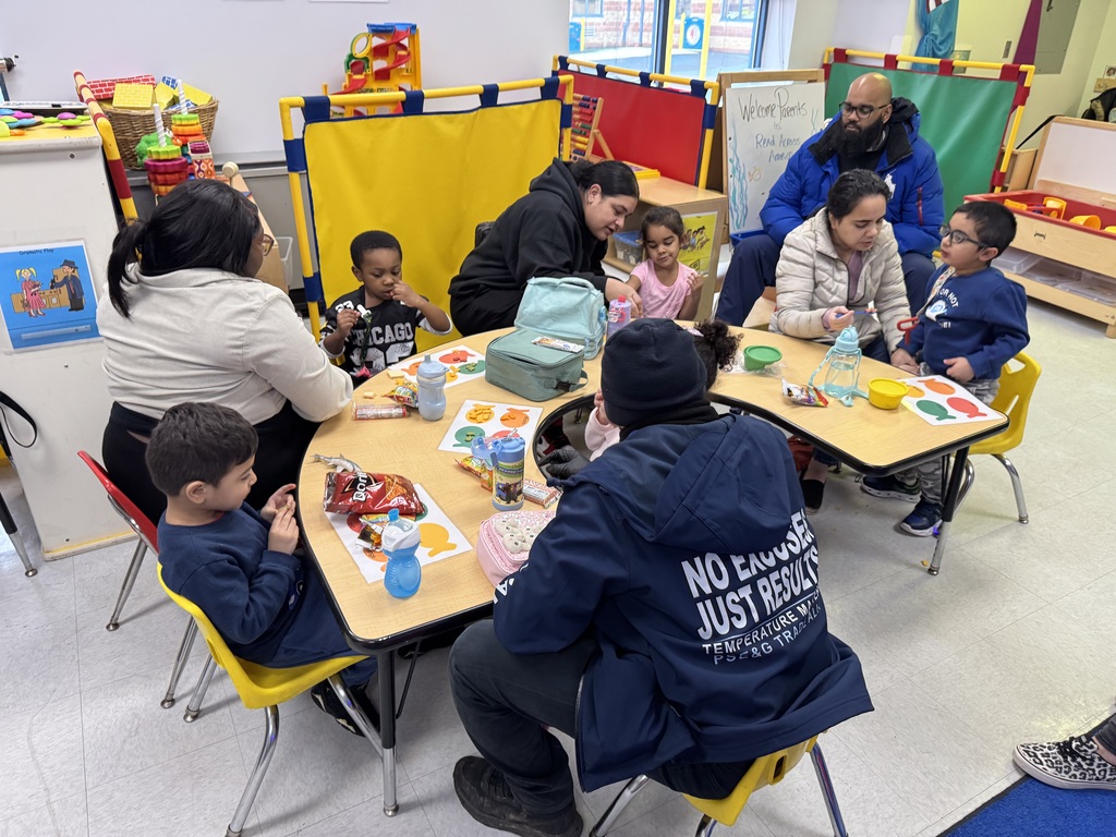 Students sitting with adults in a classroom