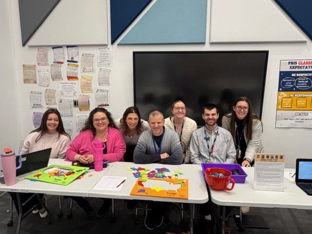 Teachers sitting at table with puzzle maps