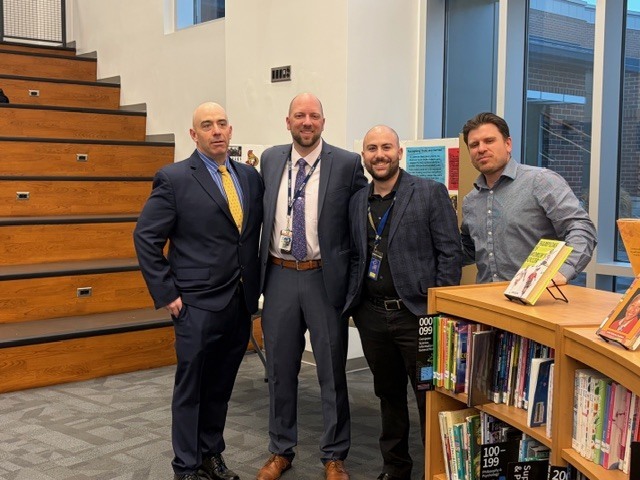 4 Teachers standing together in a library