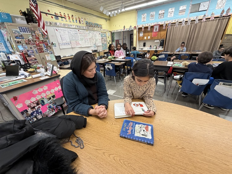 Students and adult reading in a classroom