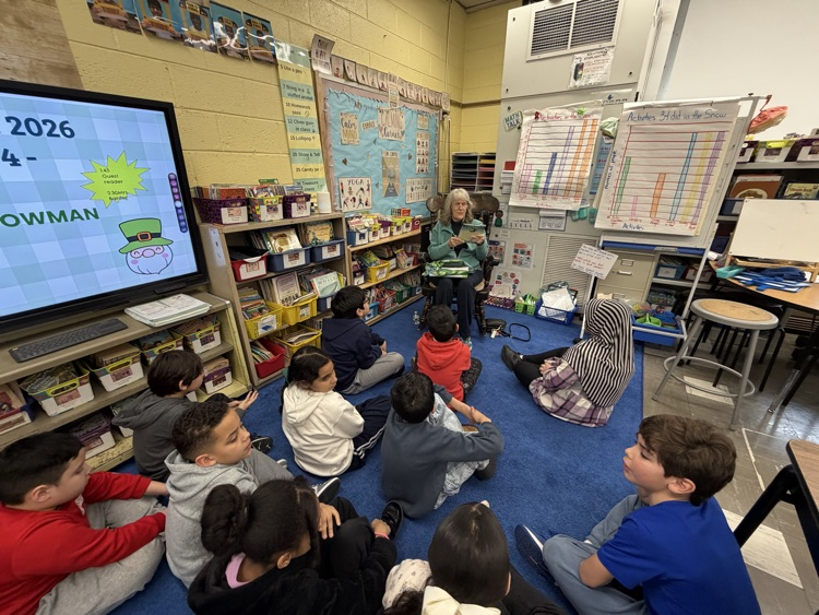 Adult reading to students in a classroom