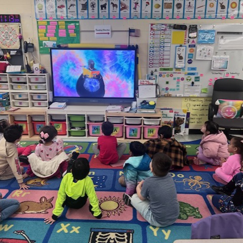 kids listening to a story on the projector board