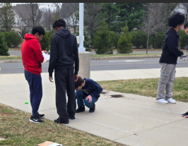 Students jumping and measuring their distances.