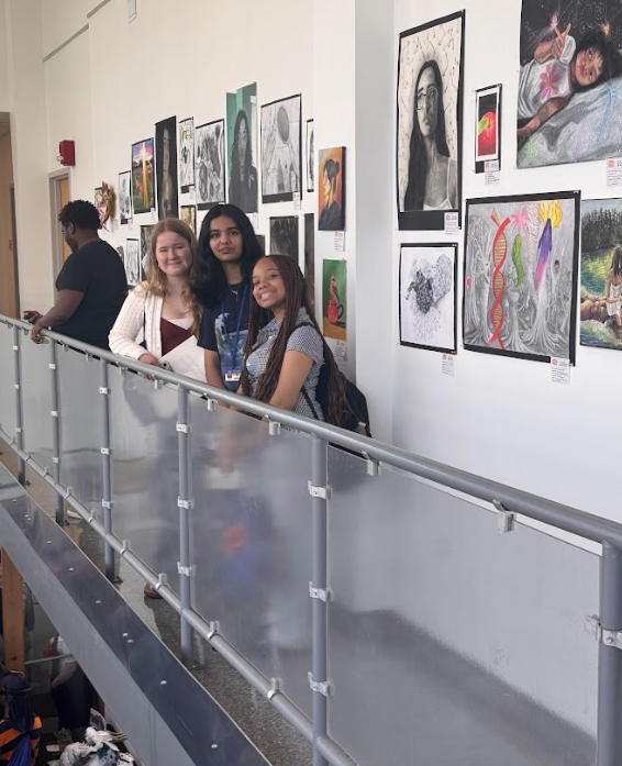 students posing in front of some art