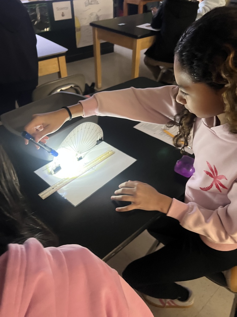 Student using flashlights for a Shadow investigation