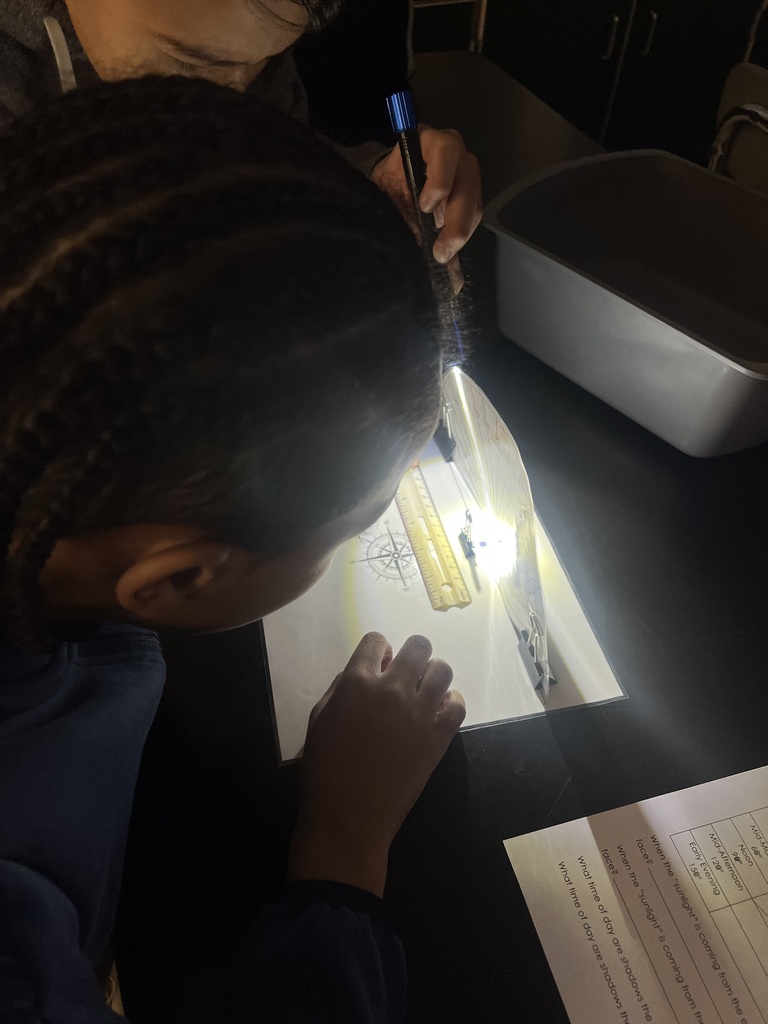 Student using flashlights for a Shadow investigation