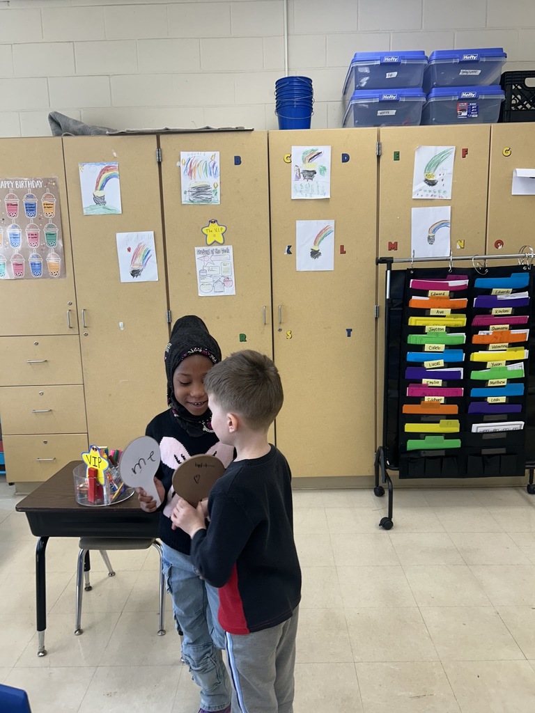 two students showing each other their dry erase boards with sight words written