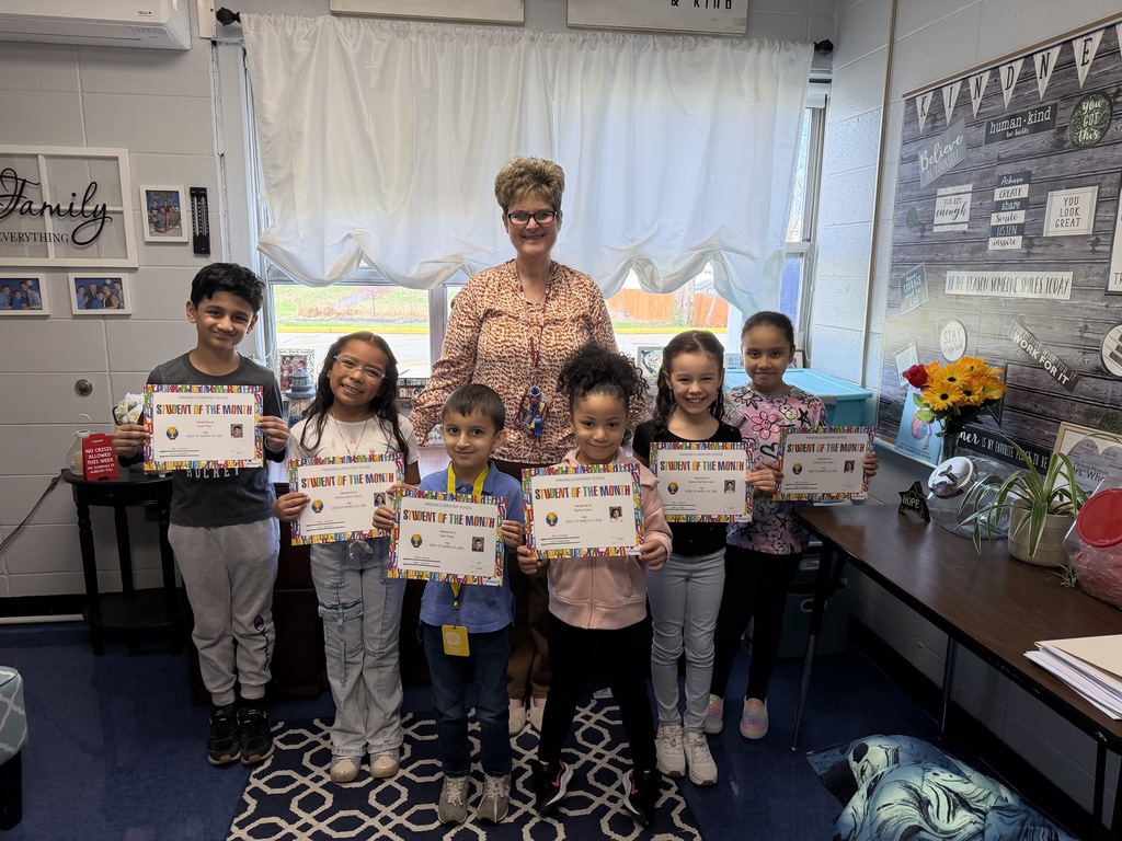 Students holding certificates posing with their principal