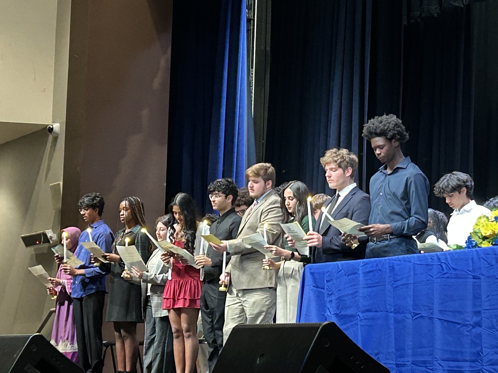 Students holding candles and reciting a pledge