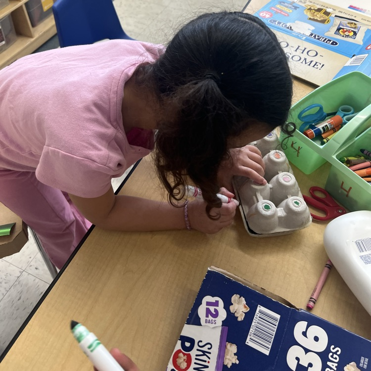 Student working with recyclable items to make projects