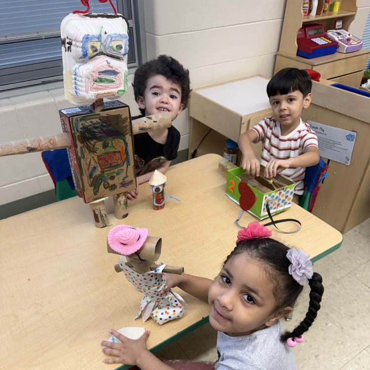 Students in a classroom looking at projects
