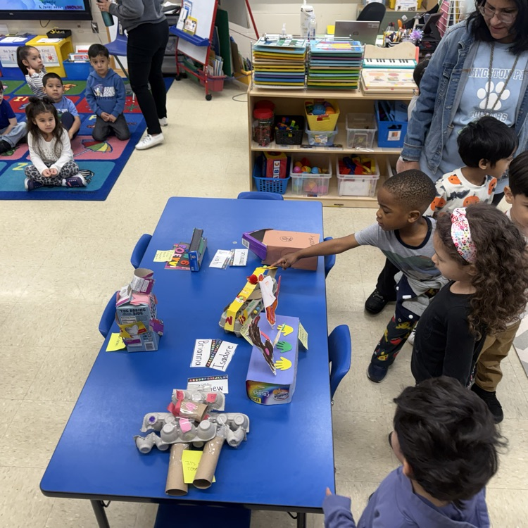 Students in a classroom looking at projects