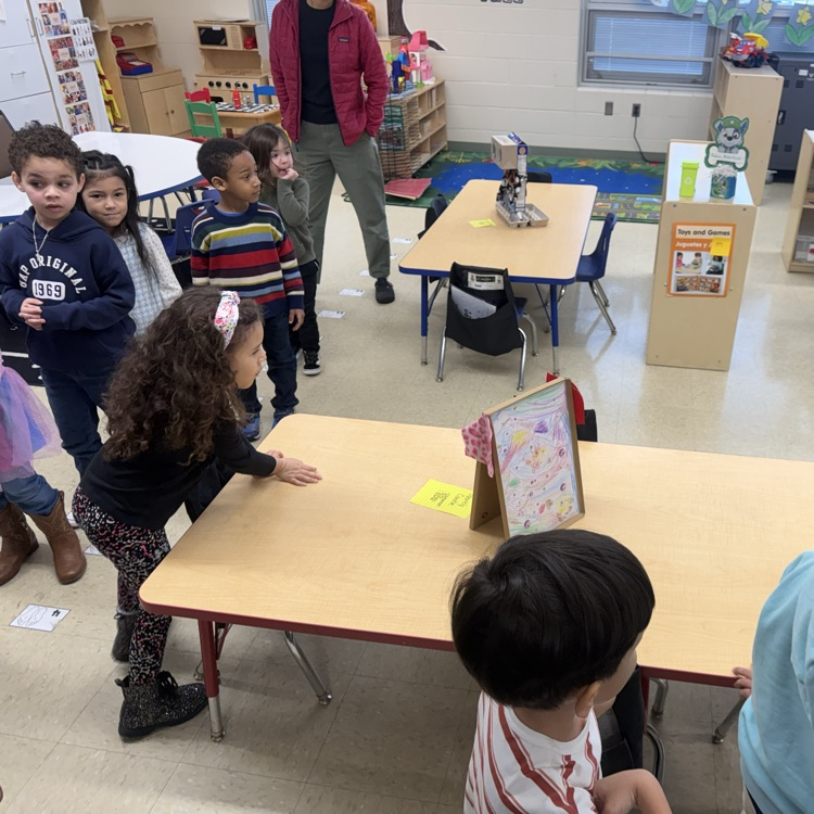 Students in a classroom looking at projects